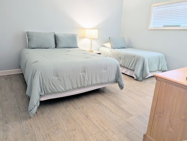 bedroom featuring baseboards and light wood finished floors
