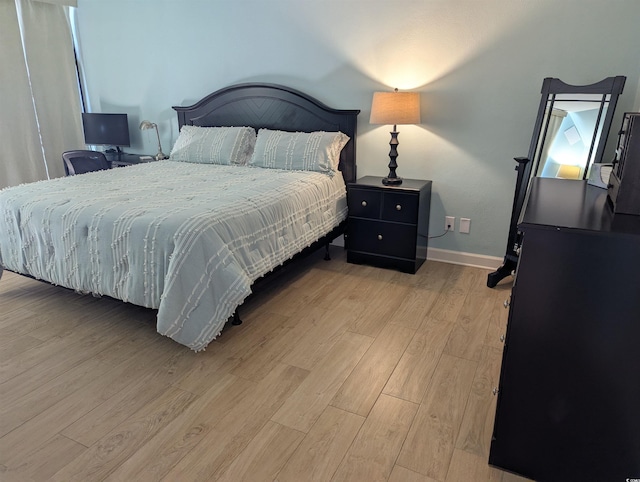 bedroom with light wood-style floors and baseboards
