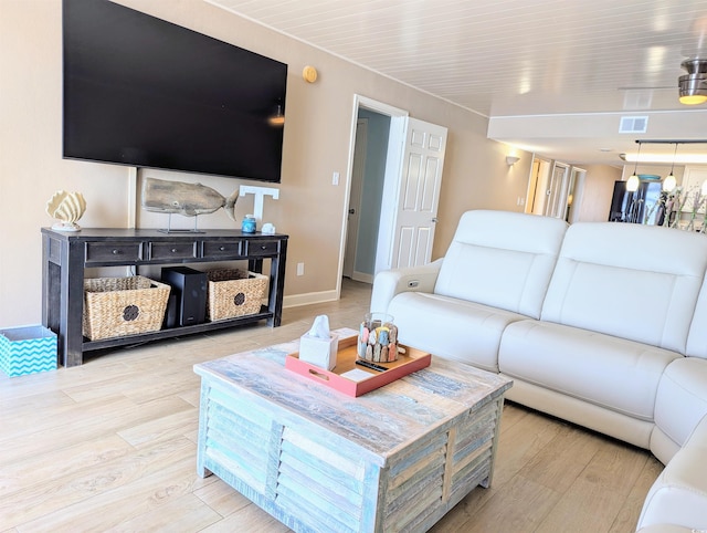 living room with wood finished floors, baseboards, and visible vents