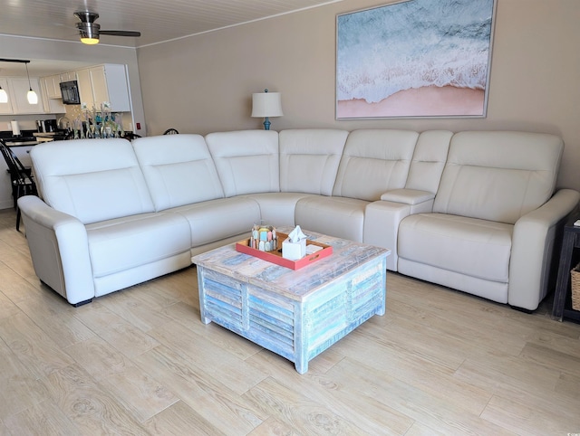 living area with light wood finished floors and ceiling fan