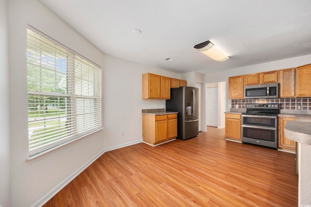 363 Junco Cir, Longs, SC 29568 - kitchen with light wood-style flooring, baseboards, decorative backsplash, light countertops, and appliances with stainless steel finishes