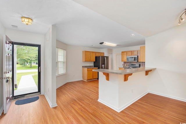 363 Junco Cir, Longs, SC 29568 - kitchen with appliances with stainless steel finishes, baseboards, a breakfast bar, a peninsula, and light wood-type flooring