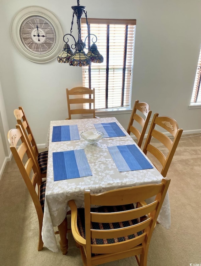 carpeted dining area featuring plenty of natural light and baseboards