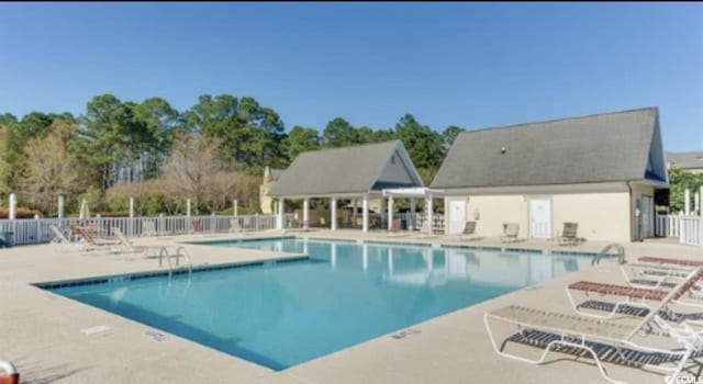 community pool featuring fence and a patio area