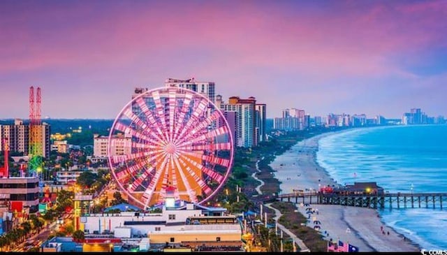 aerial view at dusk of view of water and beach and a city view