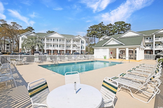 community pool featuring a patio and fence
