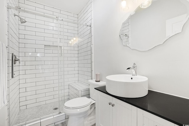 bathroom with vanity, a shower stall, and toilet