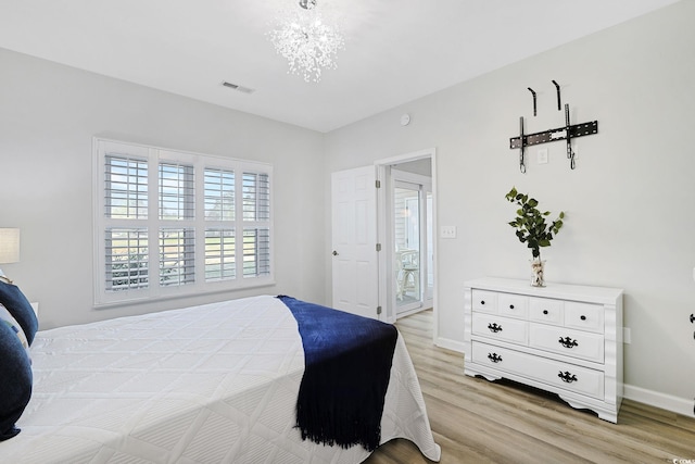 bedroom with light wood-style floors, baseboards, a chandelier, and visible vents