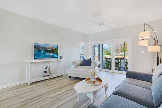 living area with baseboards, a ceiling fan, and wood finished floors