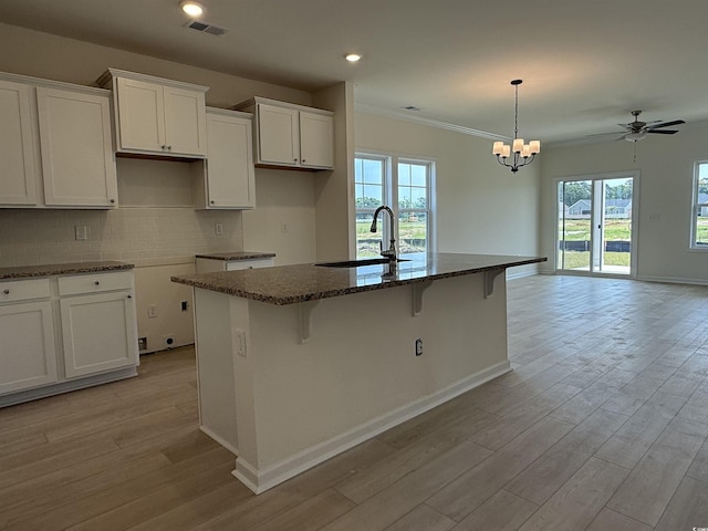 1025 Jase Dr, Longs, SC 29568 - kitchen featuring a sink, light wood-style floors, a kitchen island with sink, a kitchen bar, and white cabinetry