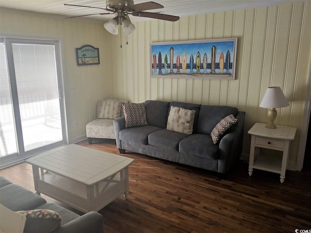 living room featuring a ceiling fan, baseboards, and wood finished floors