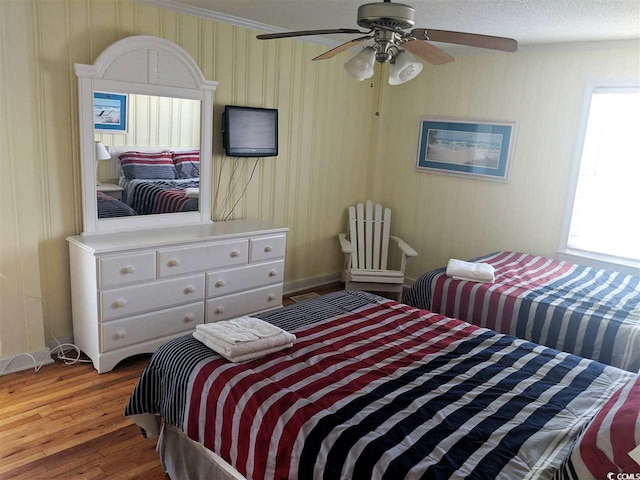 bedroom featuring baseboards, ceiling fan, and wood finished floors