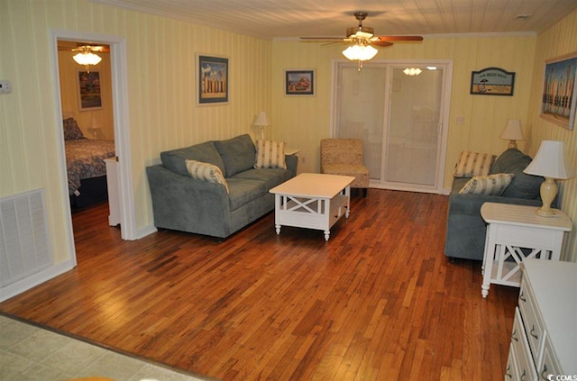 living area with crown molding, ceiling fan, and wood-type flooring