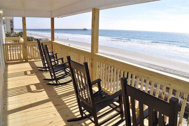 deck featuring a view of the beach and a water view