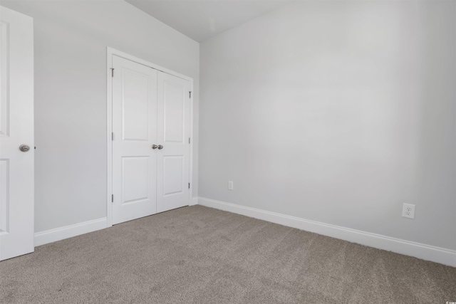 unfurnished bedroom featuring a closet, baseboards, and carpet floors