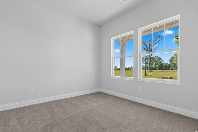 carpeted empty room featuring baseboards