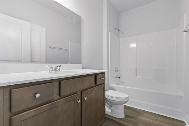 bathroom featuring toilet, shower / washtub combination, vanity, and wood finished floors