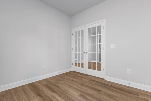 empty room with french doors, baseboards, and wood finished floors