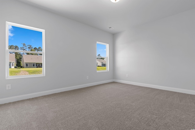 spare room featuring carpet floors, baseboards, and visible vents