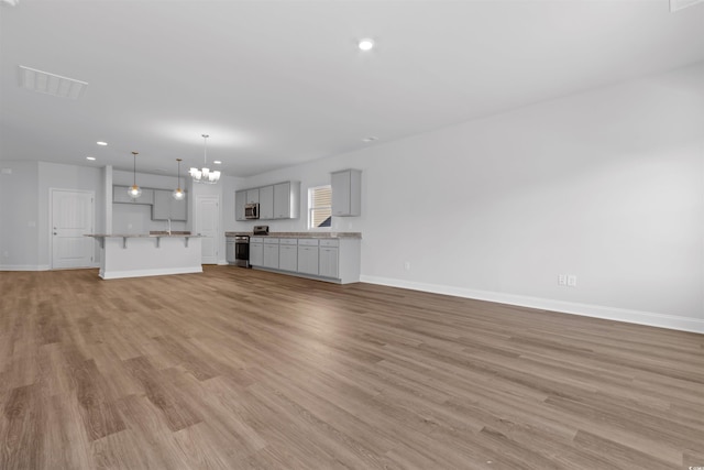 unfurnished living room featuring visible vents, baseboards, light wood finished floors, and recessed lighting