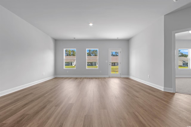 unfurnished living room with wood finished floors and baseboards