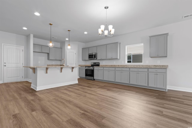 kitchen with baseboards, a chandelier, gray cabinetry, visible vents, and stainless steel appliances