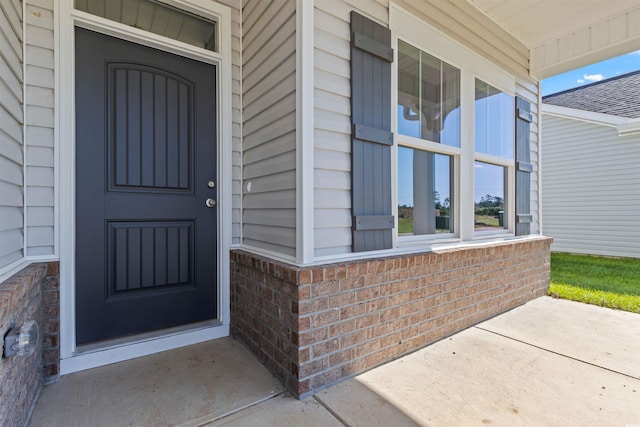 entrance to property featuring brick siding