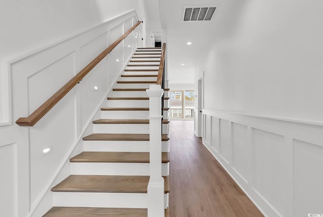 318 Vista Dr, Murrells Inlet, SC 29576 - stairway with a decorative wall, wood finished floors, a wainscoted wall, and recessed lighting