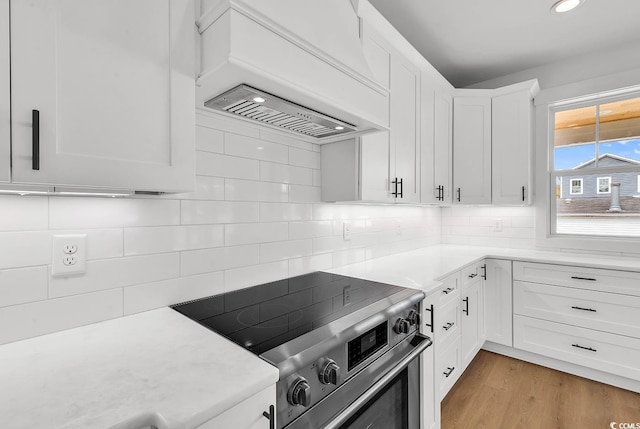 318 Vista Dr, Murrells Inlet, SC 29576 - kitchen featuring stainless steel range with electric stovetop, premium range hood, decorative backsplash, white cabinets, and recessed lighting