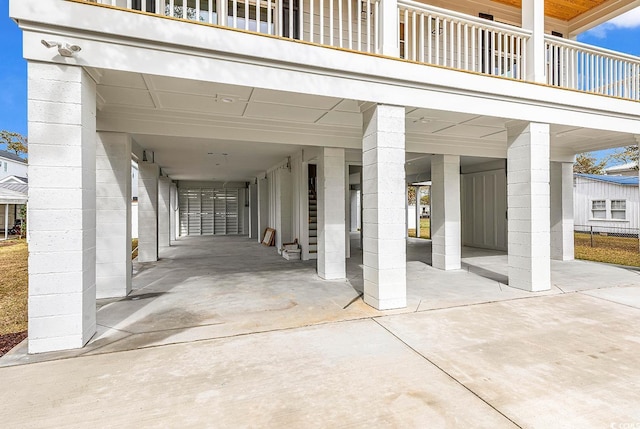 view of patio with a balcony, a carport, and concrete driveway