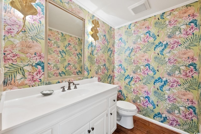 bathroom with visible vents, toilet, vanity, and wood finished floors