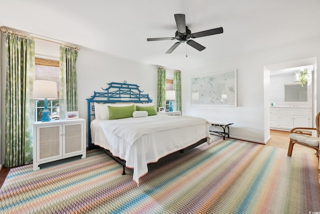 bedroom featuring ensuite bathroom, a ceiling fan, and wood finished floors
