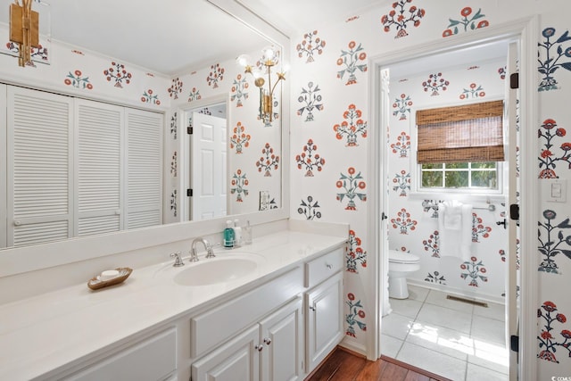 bathroom featuring tile patterned floors, toilet, vanity, and wallpapered walls