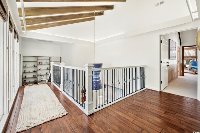 corridor featuring visible vents, baseboards, wood finished floors, and lofted ceiling with beams