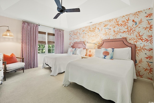 bedroom featuring light colored carpet, a ceiling fan, visible vents, wallpapered walls, and baseboards