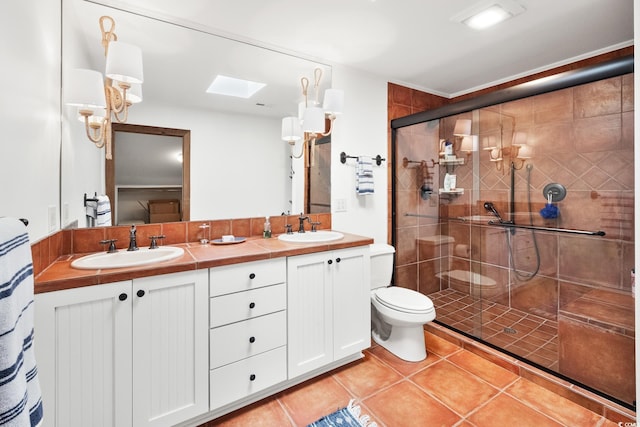 bathroom featuring a sink, tile patterned floors, toilet, and a shower stall