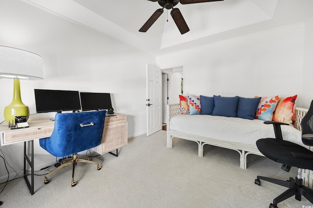 office with a tray ceiling, carpet flooring, and a ceiling fan