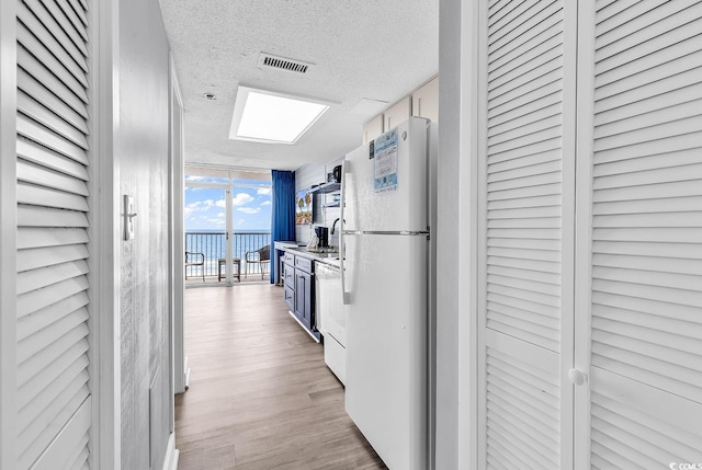 161 Sea Watch Dr Unit 614, Myrtle Beach, SC 29572 - corridor with a textured ceiling, light wood finished floors, expansive windows, and a water view