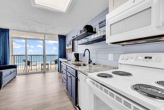 161 Sea Watch Dr Unit 614, Myrtle Beach, SC 29572 - kitchen featuring white appliances, a sink, a water view, light wood finished floors, and expansive windows