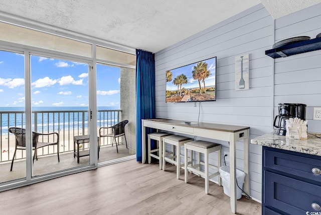 161 Sea Watch Dr Unit 614, Myrtle Beach, SC 29572 - interior space with a textured ceiling, light wood-style flooring, floor to ceiling windows, and wooden walls