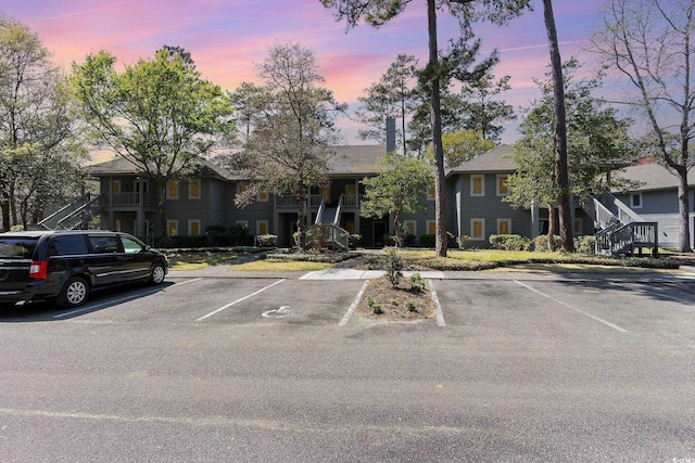 multi unit property featuring stairs and uncovered parking