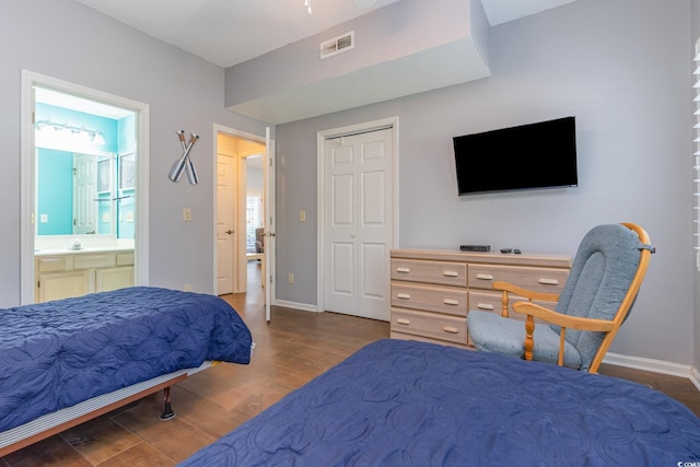 bedroom with wood finished floors, baseboards, and ensuite bathroom