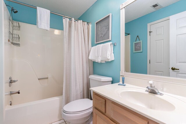 full bath featuring toilet, shower / tub combo with curtain, vanity, and a textured ceiling