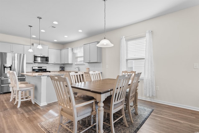 dining room featuring baseboards, visible vents, recessed lighting, and light wood-type flooring