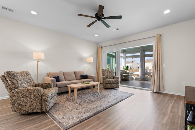 living room featuring wood finished floors, ceiling fan, and visible vents