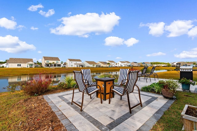 view of patio / terrace with a water view, an outdoor fire pit, and a residential view