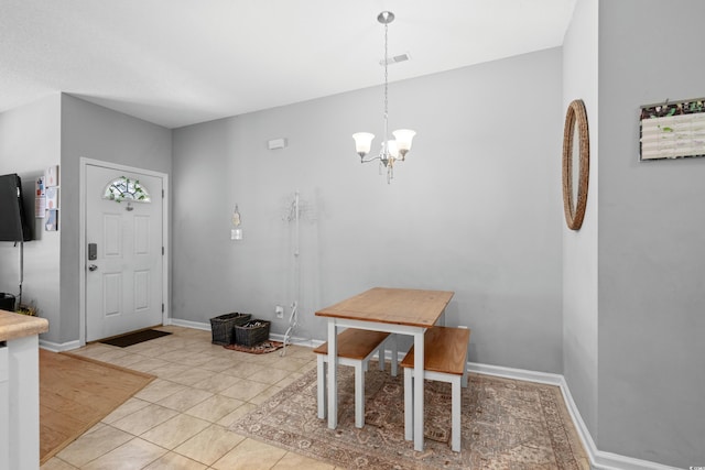 dining room featuring a chandelier, light tile patterned flooring, and baseboards
