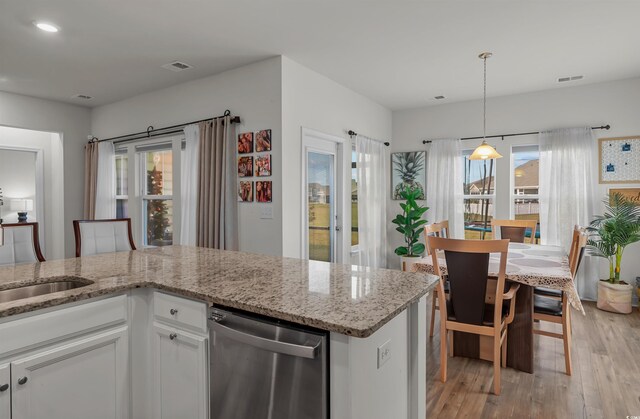 1176 Harbison Cir, Myrtle Beach, SC 29579 - kitchen with dishwasher, light wood-style floors, white cabinets, light stone countertops, and pendant lighting