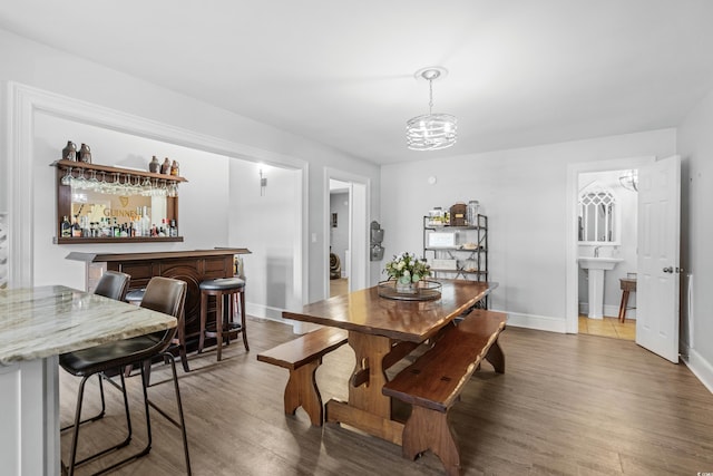 160 Shipmaster Ave, Pawleys Island, SC 29585 - dining area featuring a dry bar, wood finished floors, baseboards, and a chandelier