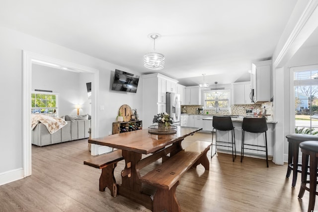 160 Shipmaster Ave, Pawleys Island, SC 29585 - dining area with healthy amount of natural light, light wood finished floors, and a chandelier